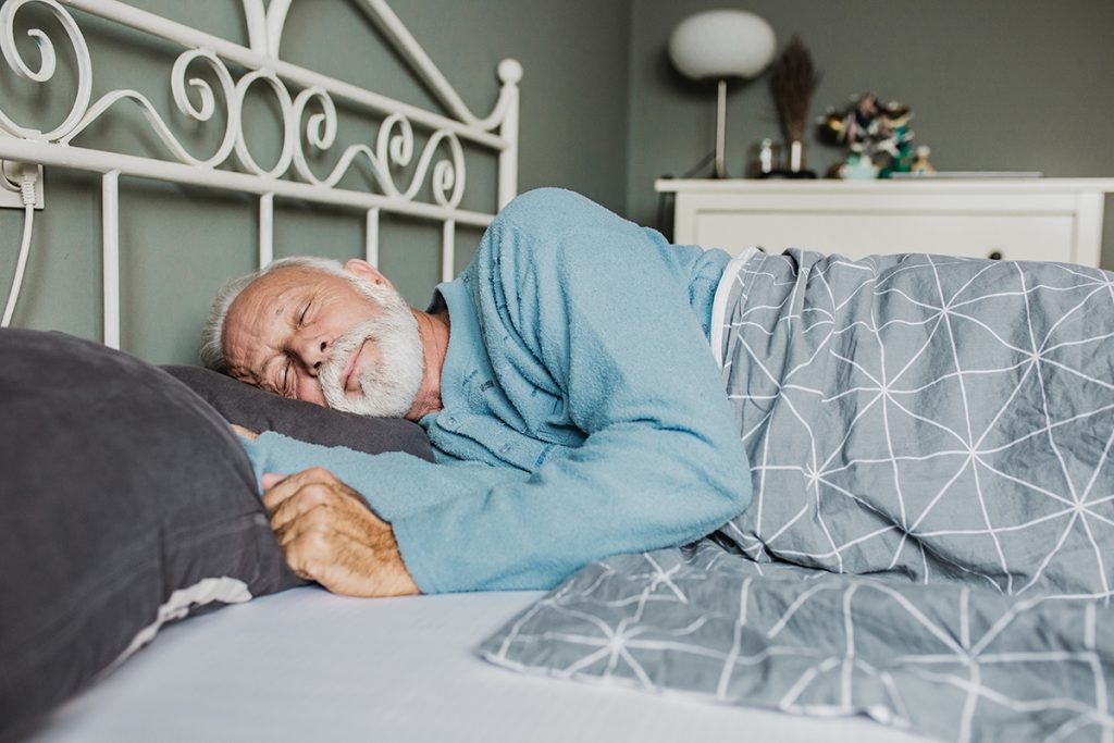 Un adulto mayor durmiendo plácidamente para preservar su función cognitiva.