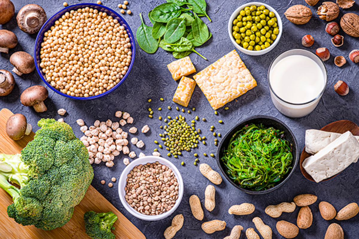 Alimentos que contienen calcio y fibra para reducir el riesgo de cáncer colorrectal sobre un fondo gris.
