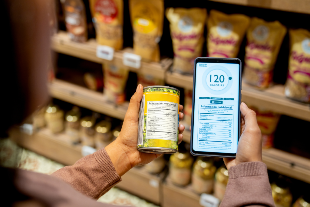 Una mujer revisando la etiqueta calórica de un alimento enlatado en un supermercado. 
