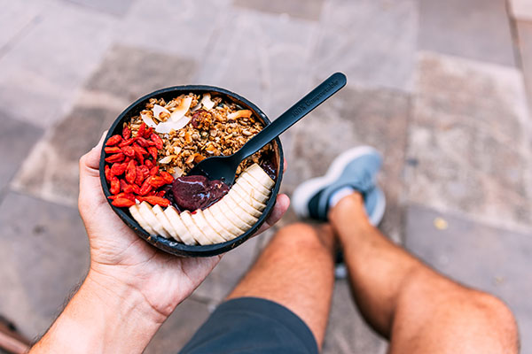 eating-healthy-acai-bowl-with-goji-berries-granola-and-banana-personal-perspective-view