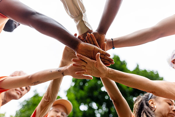 multiracial-volunteers-stacking-hands-during-environmental-cleanup-program