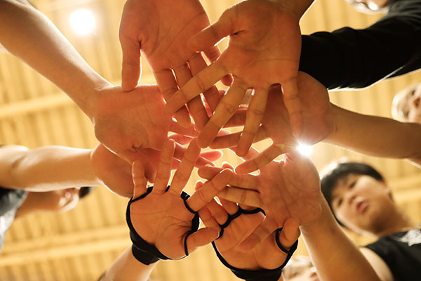 athletes-pile-their-hands-together-in-a-circle