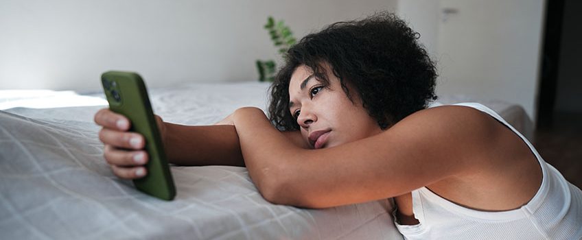 digital-devices-and-mental-health-upset-african-american-woman-looking-at-smartphone-screen-feeling-sad-reading-sms-message-scrolling-on-social-media