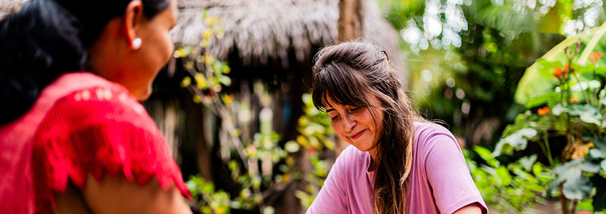 tourist-and-indigenous-woman-preparing-casabe-traditional-amazon-bread-in-guainia-colombia